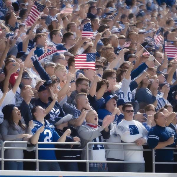 BYU football fans cheering during a military recognition moment with many holding American flags.