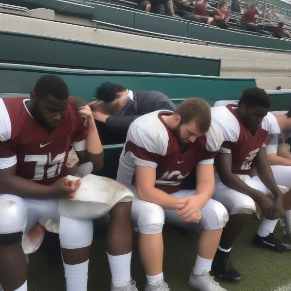 Exhausted Football Players on Bench