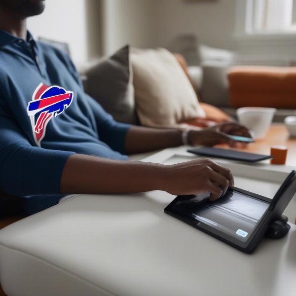 man-using-streaming-device-to-watch-bills-game