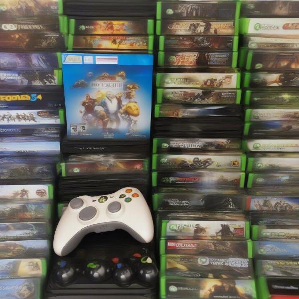 An Xbox 360 controller with a variety of games in the background