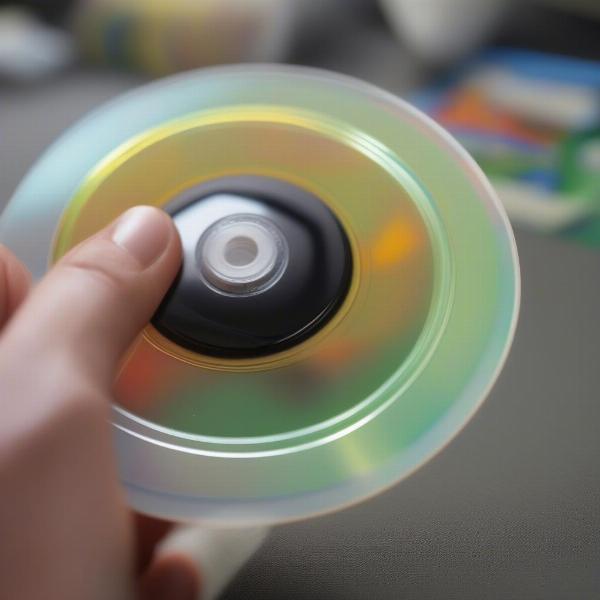 person cleaning a xbox 360 game disc with a cloth